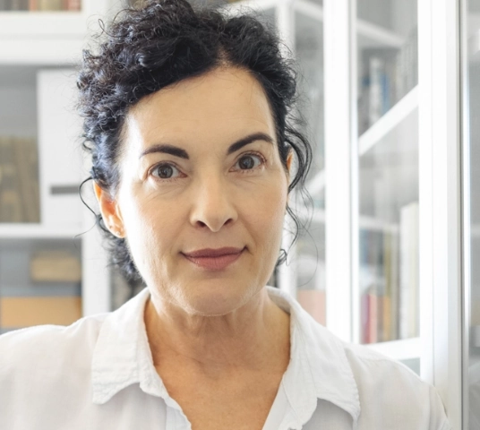 Photo of “Eva,” looking straight into camera, hair pulled back